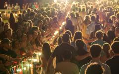 Wren Courtyard lit at night filled with, with new students walking down a brick path lined with members of campus offering high-fives