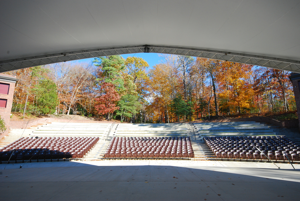 View from the stage. Tent overhead looking onto seats and woods.