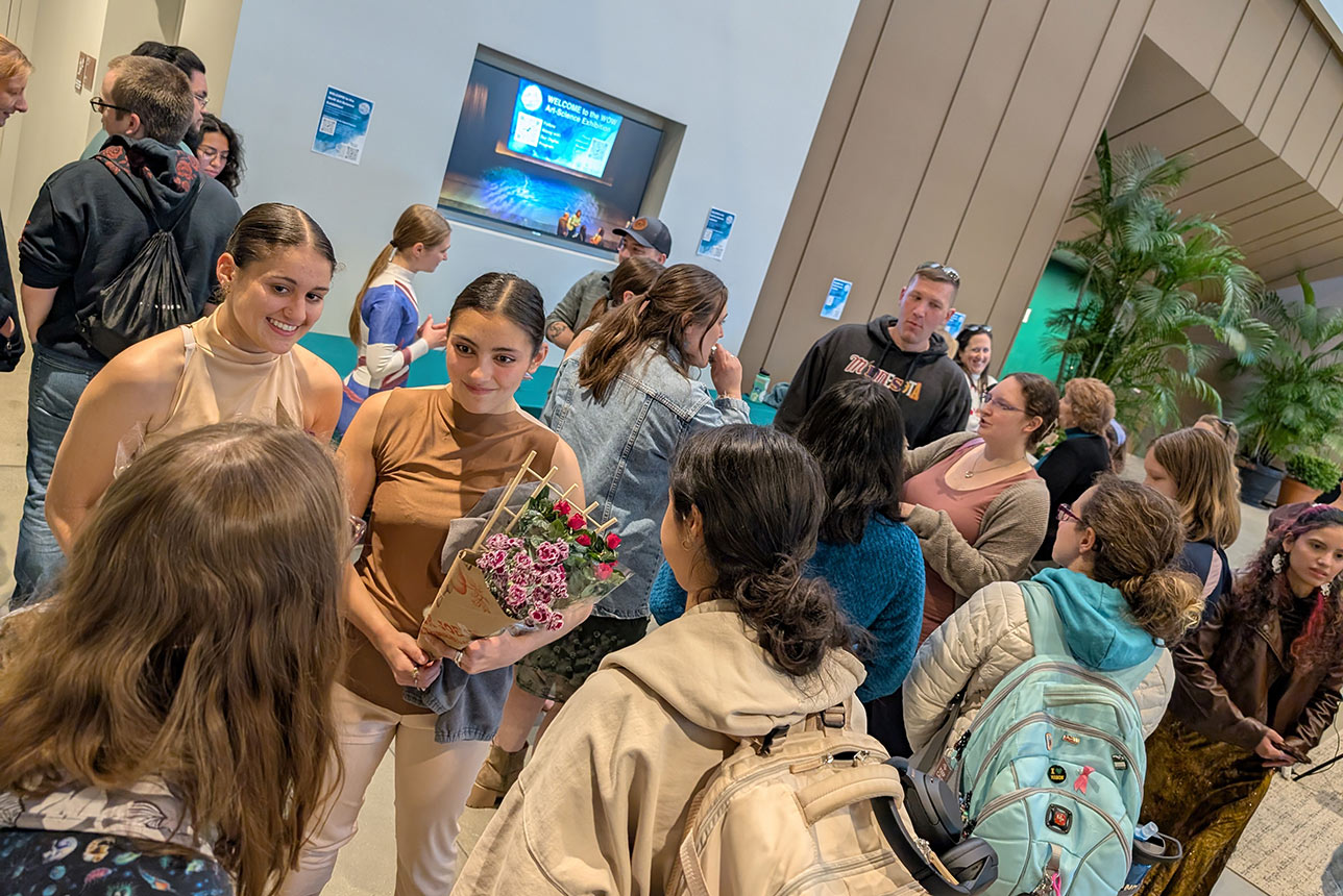 Students and supporters gathered in a lobby smiling and talking