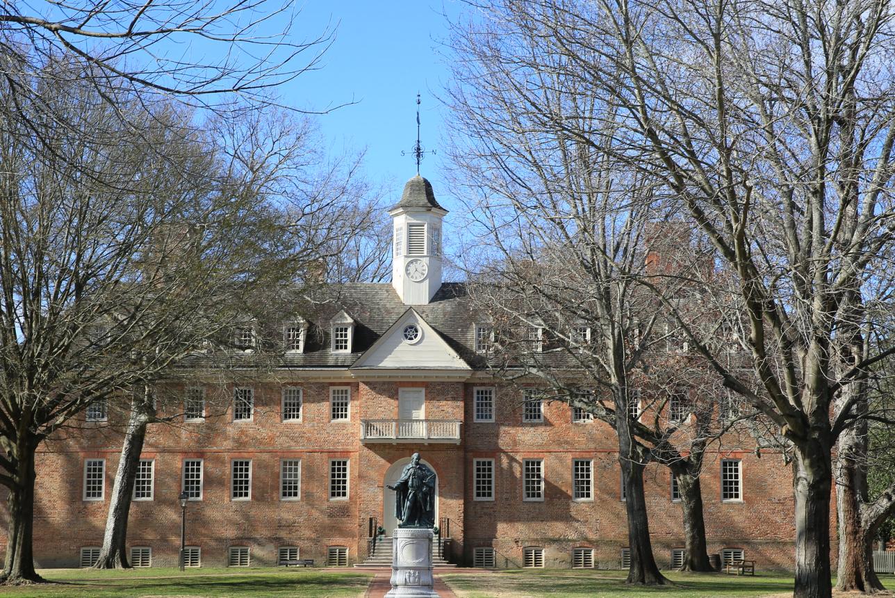 A photo showcases the Wren Building and the surrounding landscape with clear skies in the background.